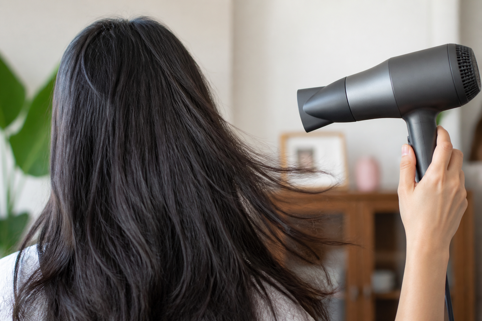 Tóc gần khô được sấy bằng luồng gió dịu với máy luôn di chuyển